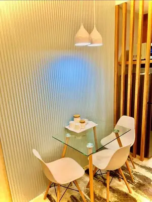 a dining room with a glass table and two chairs at Shore 3, Mall of Asia Complex in Manila
