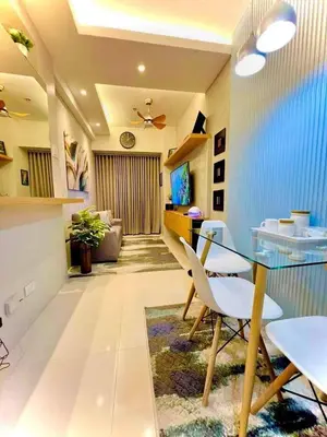 a dining room with a glass table and white chairs at Shore 3, Mall of Asia Complex in Manila