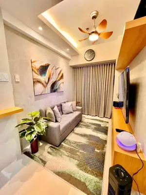 a living room with a couch and a tv at Shore 3, Mall of Asia Complex in Manila
