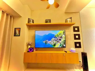 a flat screen tv sitting on top of a wooden entertainment center at Shore 3, Mall of Asia Complex in Manila