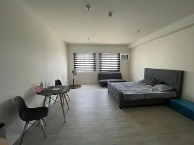 a bedroom with a bed and a table and a couch at Nuvali Amaia steps parkway in Calamba