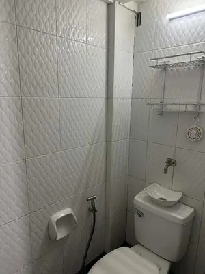 a white bathroom with a toilet and a sink at Cozy Loft Unit in Manila in Manila