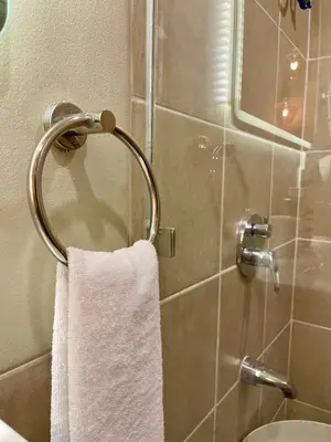 a white towel hanging on a towel rack in a bathroom at Balé Cù Calathea Place near airport road NAIA and MOA in Manila