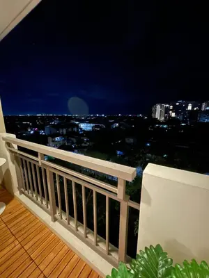 a balcony with a view of a city at night at Balé Cù Calathea Place near airport road NAIA and MOA in Manila