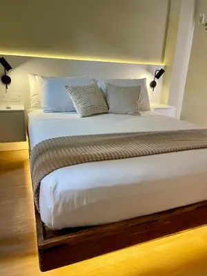 a large bed with white sheets and pillows at Balé Cù Calathea Place near airport road NAIA and MOA in Manila