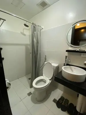 a white bathroom with a toilet and a sink at Kasara T14K Cozy Abode in Manila