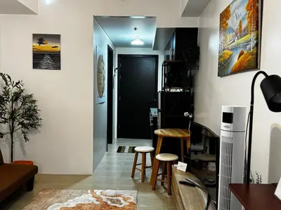 a living room with a table and two stools at Kasara T14K Cozy Abode in Manila