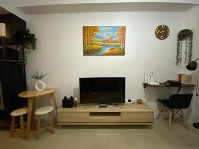 a living room with a flat screen tv on a table at Kasara T14K Cozy Abode in Manila