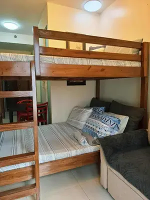 a bedroom with two bunk beds and a couch at Sunshine100PioneermMandaluyong PoolGymBilliardsPlaygroundTVWifi in Manila
