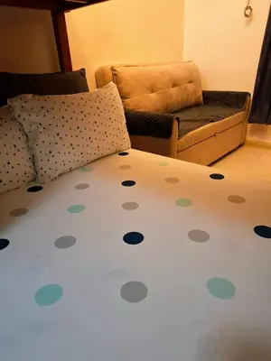 a bed with polka dots on it next to a couch at Sunshine100PioneermMandaluyong PoolGymBilliardsPlaygroundTVWifi in Manila