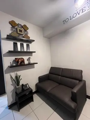 a living room with a brown couch and shelves at Mandaluyong HomeBest Place to Stay! in Manila
