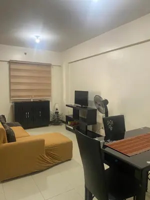 a living room with a bed and a desk with a laptop at Resort Inspired Condo Beside NAIA Terminal 1 Near Okada and City of Dreams in Manila