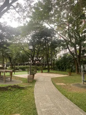 a path in a park with a bench and trees at Resort Inspired Condo Beside NAIA Terminal 1 Near Okada and City of Dreams in Manila