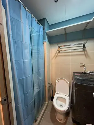 a bathroom with a toilet and a glass shower at MK's place in Manila