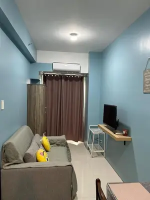 a living room with a couch and a television at MK's place in Manila