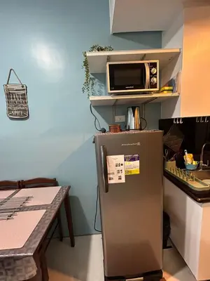 a kitchen with a microwave on top of a refrigerator at MK's place in Manila