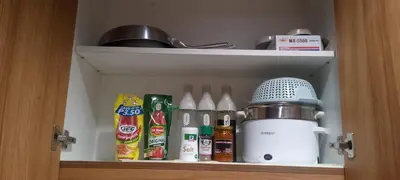 a cupboard with a mixer and other kitchen items at The Azelea Suites By Azel in Manila