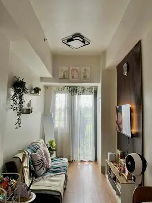 a living room with a couch in front of a window at The Azelea Suites By Azel in Manila