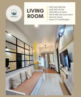 a living room with a large couch and a tv at Cozy Family Suite at Fame Residences Tower 2 Mandaluyong in Manila