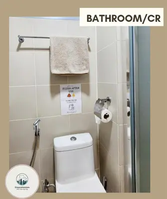 a bathroom with a toilet and a shower stall at Cozy Family Suite at Fame Residences Tower 2 Mandaluyong in Manila