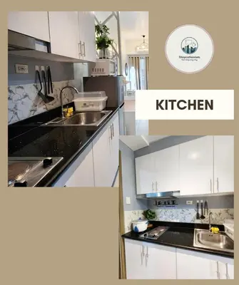 a kitchen with white cabinets and black counter tops at Cozy Family Suite at Fame Residences Tower 2 Mandaluyong in Manila