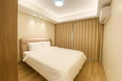 a small bedroom with a bed with white sheets at Manila City Center Executive Apartments near Ayala Mall and PITX in Manila