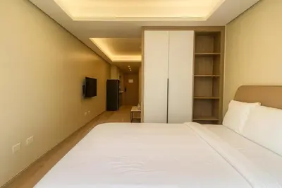 a bedroom with a bed and a tv at Manila City Center Executive Apartments near Ayala Mall and PITX in Manila