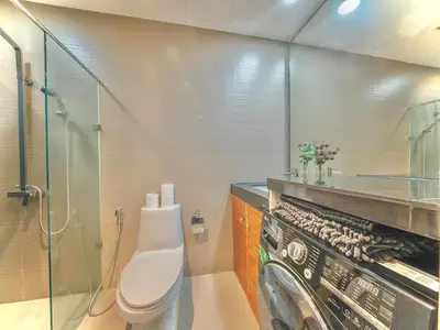 a bathroom with a toilet and a washing machine at Haven in the Park in Manila