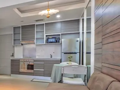 a kitchen with a table and a refrigerator at Haven in the Park in Manila