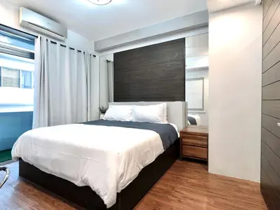 a bedroom with a large bed and a window at Haven in the Park in Manila