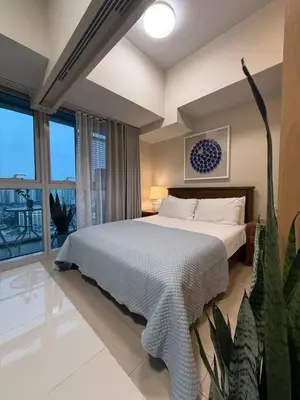 a bedroom with a bed and a large window at Uptown Parksuites Sun scenic city escape 22T in Manila
