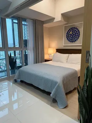 a bedroom with a bed and a large window at Uptown Parksuites Sun scenic city escape 22T in Manila