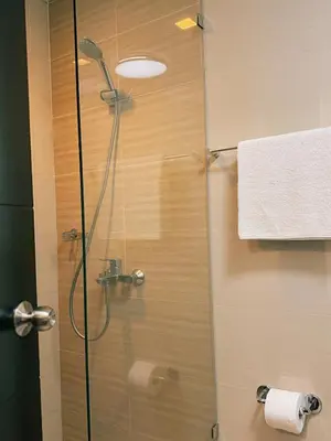 a shower in a bathroom with a glass door at Uptown Parksuites Sun scenic city escape 22T in Manila