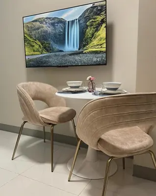 a table and chairs with a waterfall painting on the wall at Uptown Parksuites Sun scenic city escape 22T in Manila