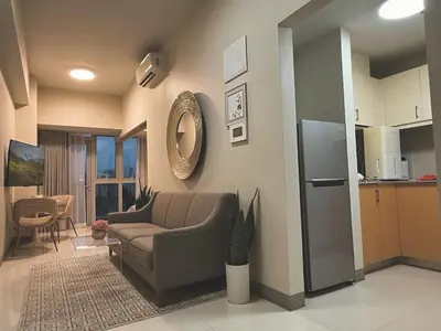 a living room with a couch and a refrigerator at Uptown Parksuites Sun scenic city escape 22T in Manila