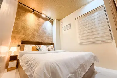 a bedroom with a large bed and a window at Lunan by SKI - Boutique Hotel in Taytay Rizal in Taytay