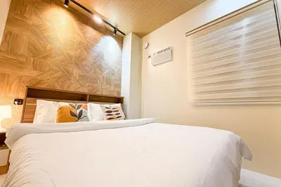 a bedroom with a white bed and a window at Lunan by SKI - Boutique Hotel in Taytay Rizal in Taytay