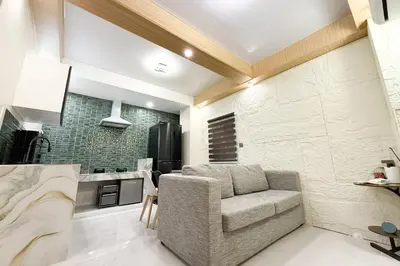 a living room with a chair and a kitchen at Lunan by SKI - Boutique Hotel in Taytay Rizal in Taytay
