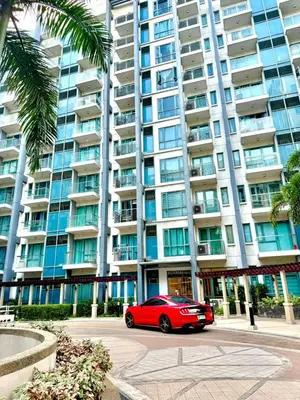 a red car parked in front of a large building at 1 bedroom Condotels Across terminal 3 airport in Manila