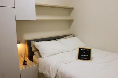 a bedroom with a bed with a sign on it at Cozy & Affordable Staycation Melrose Haven in Manila