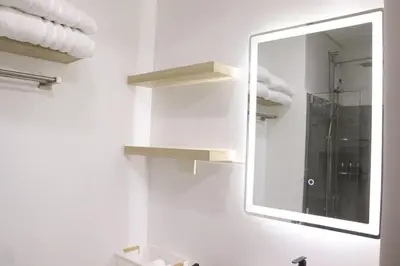 a bathroom with a mirror and a sink with towels at Cozy & Affordable Staycation Melrose Haven in Manila
