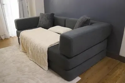 a gray couch with a blanket on it in a room at Cozy & Affordable Staycation Melrose Haven in Manila