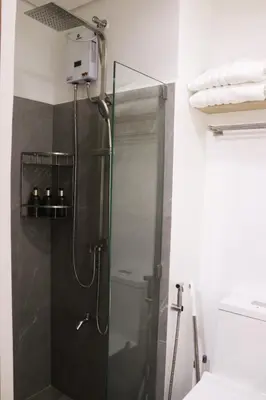 a shower with a glass door in a bathroom at Cozy & Affordable Staycation Melrose Haven in Manila