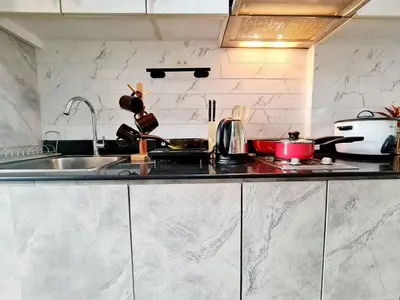 a kitchen with a sink and a counter top at Cozy MOA View Stay - Walk to Mall of Asia in Manila