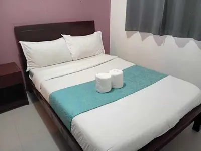 a bed with two rolls of toilet paper on it at Shandong Residences in Manila