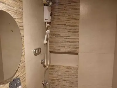a shower in a bathroom with a mirror at Shandong Residences in Manila
