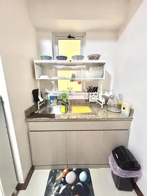 a kitchen counter with a sink and a window at Spacious 3BR 2 balcony Resort vibes near BGC in Manila