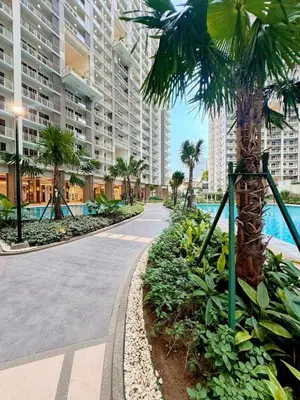 a walkway with a palm tree in front of a building at Spacious 3BR 2 balcony Resort vibes near BGC in Manila