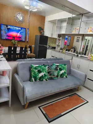 a living room with a couch and a kitchen at Juliza Staycation near Mall Of Asia in Manila
