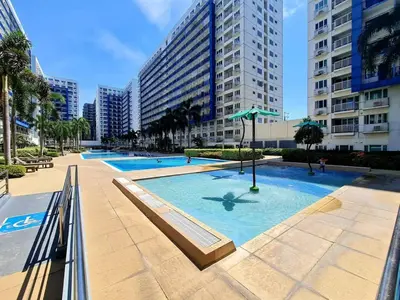 a large swimming pool in a city with tall buildings at Juliza Staycation near Mall Of Asia in Manila